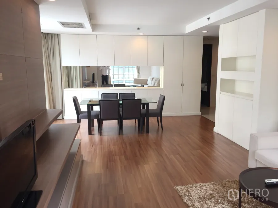 คอนโด ให้เช่าในPathum Wan, Bangkok - พื้นที่นั่งเล่นและรับประทานอาหารแบบโอเพ่น โปร่งสว่าง พื้นไม้ โต๊ะกระจก และตู้บิวท์อินสีขาวพร้อมกระจกบานยาว