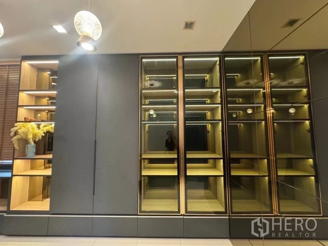 Detached House for rent in Saphan Sung, Bangkok - Illuminated built-in display cabinets with glass doors and shelving in a modern living area.