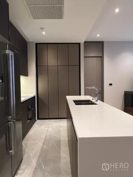 คอนโด ให้เช่าในWatthana, Bangkok - ครัวแบบกาลีย์พร้อมไอส์แลนด์ท็อปสีขาวยาว ซิงก์ และตู้เก็บของบานด้าน