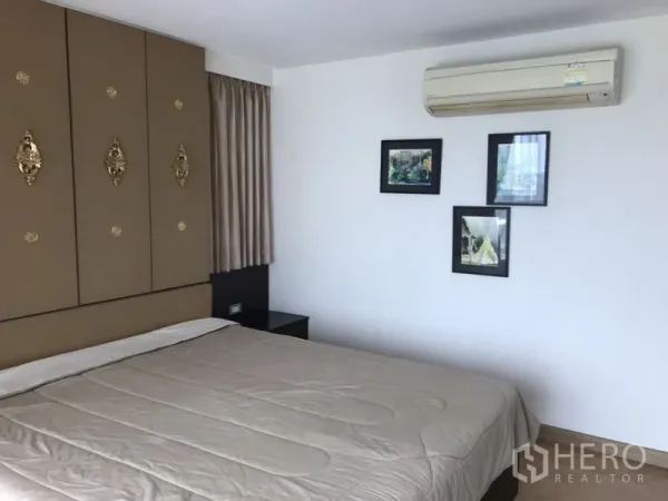 公寓 出租在Watthana, Bangkok - 卧室配装饰壁板、墙面装饰画、空调与大床，色调素雅。