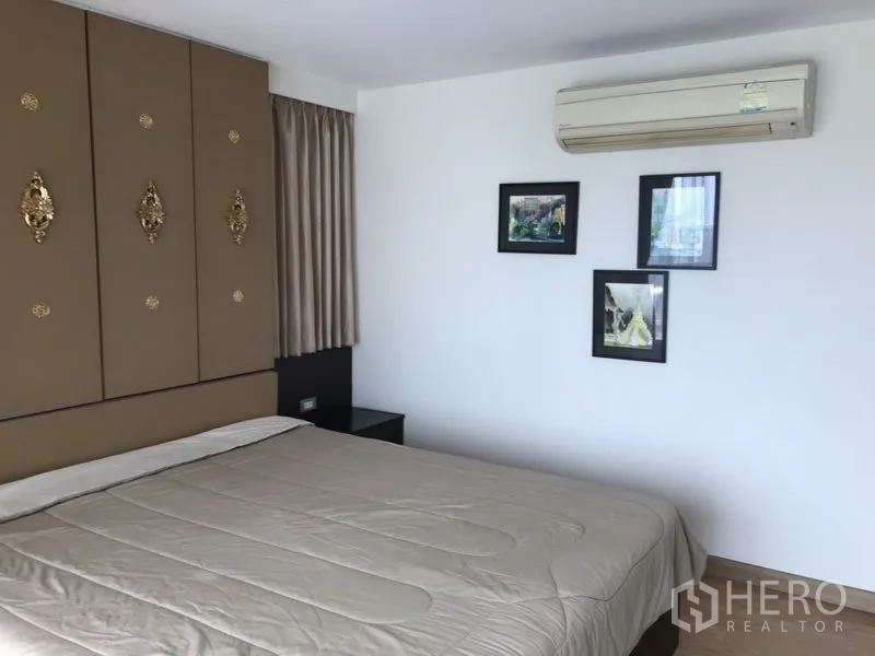 公寓 出租在Watthana, Bangkok - 卧室配装饰壁板、墙面装饰画、空调与大床，色调素雅。
