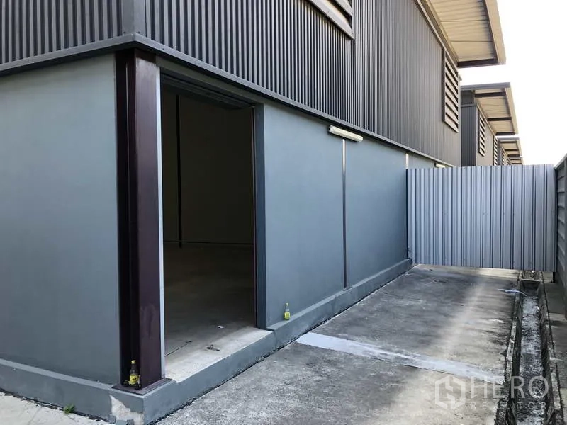 货栈 出租在Bang Phli, Samut Prakan - 侧院入口，仓库侧墙开口与金属门。