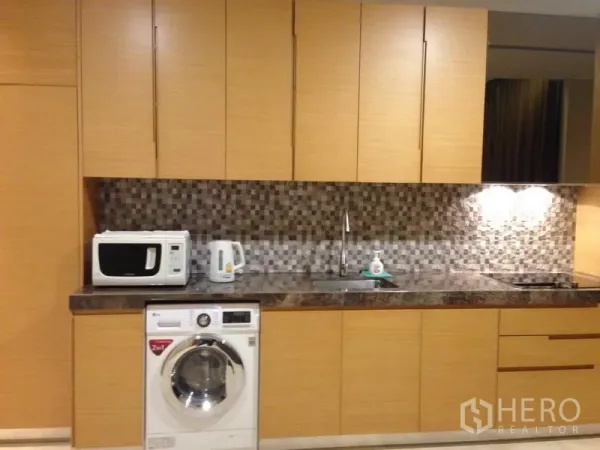 公寓 出售在Bang Rak, Bangkok - 现代厨房，木质柜体、马赛克防溅墙、石面台，并带洗衣机。