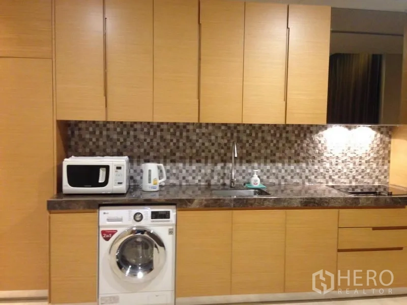 公寓 出售在Bang Rak, Bangkok - 现代厨房，木质柜体、马赛克防溅墙、石面台，并带洗衣机。