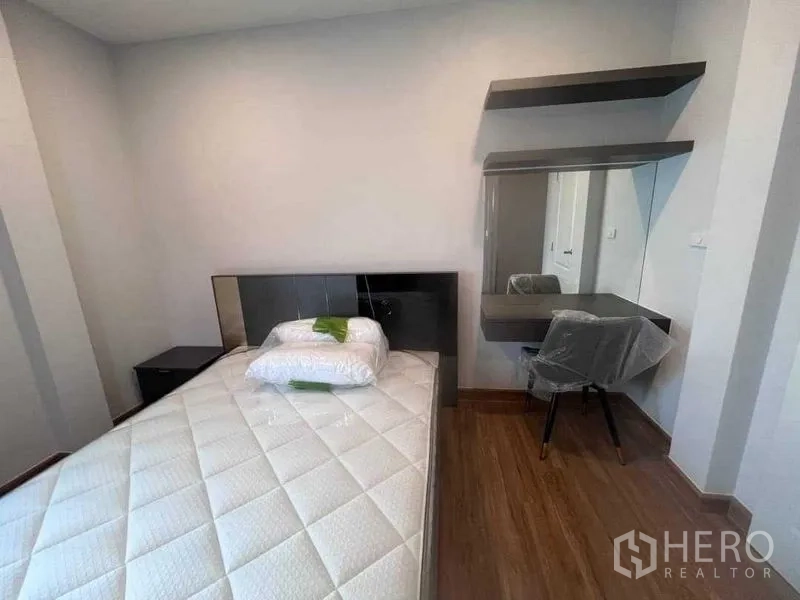 Detached House for rent in Don Mueang, Bangkok - Cozy bedroom with single bed, side table and floating shelves with a mirror desk.
