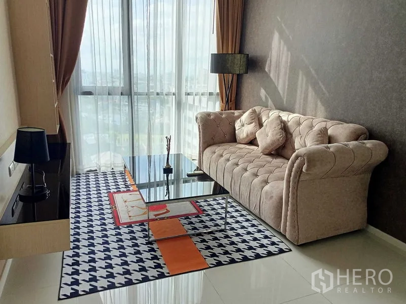 คอนโด ให้เช่าในWatthana, Bangkok - ห้องนั่งเล่นสว่างด้วยโซฟากำมะหยี่สีเบจ หน้าต่างกระจกเต็มบาน ผ้าม่านโปร่ง และโต๊ะกลางกระจก.