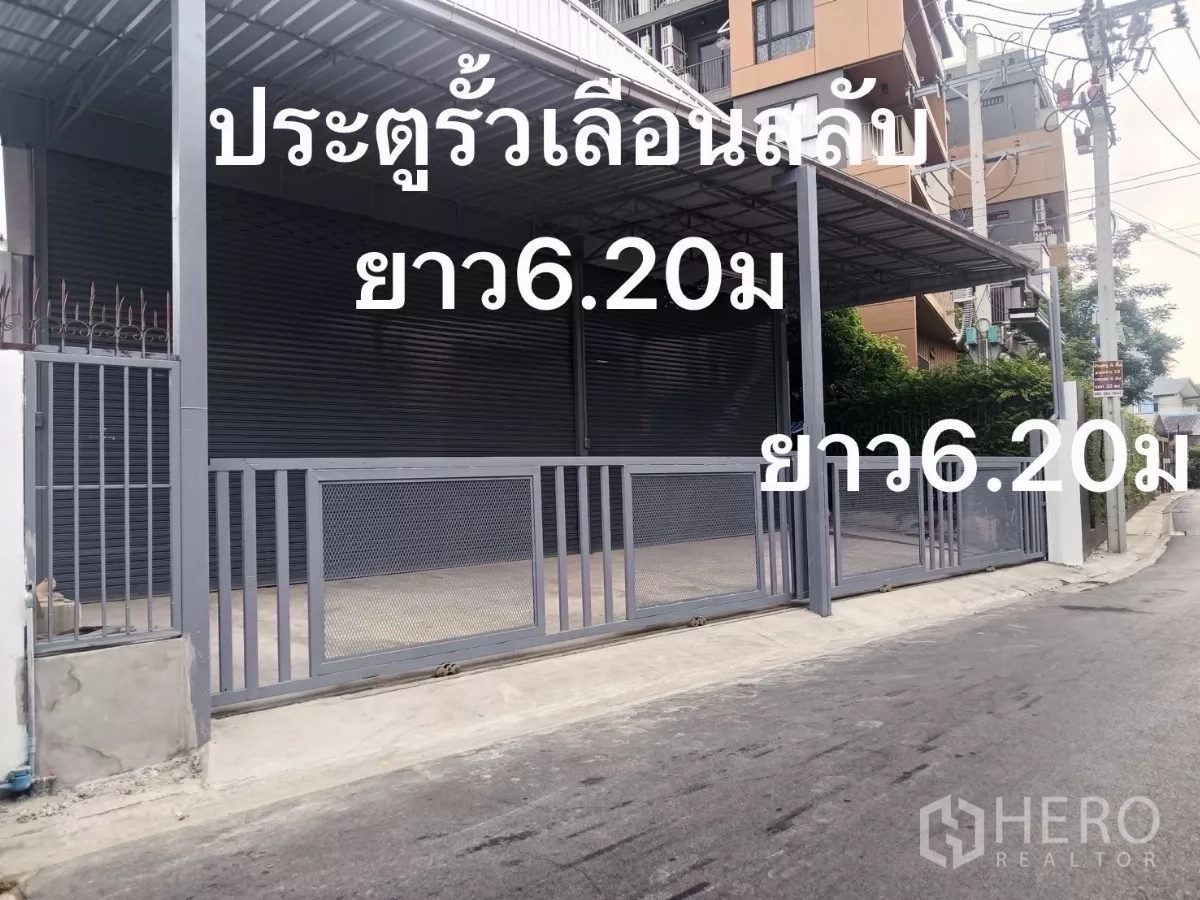 Warehouse for rent in Huai Khwang, Bangkok - Street-facing warehouse exterior with a gated, covered loading bay and roller shutters.