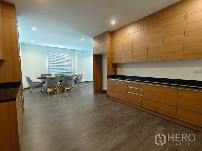 Detached House for rent or sale - Kitchen connecting to dining space, featuring abundant cabinets and black countertops.