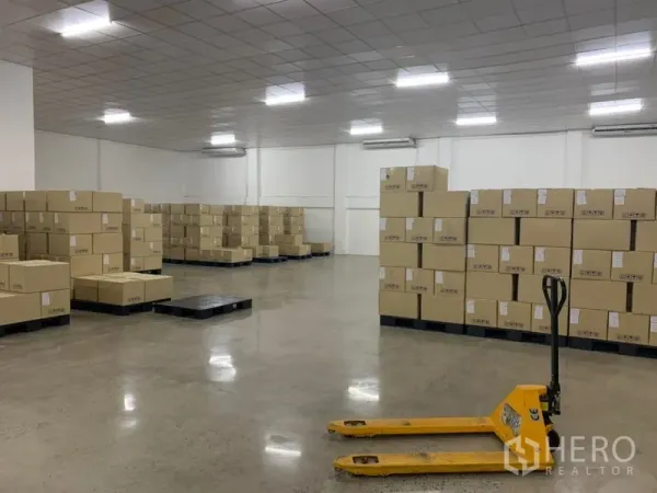 คลังสินค้า ให้เช่าในYan Nawa, Bangkok - พื้นที่เก็บกว้าง กล่องบนพาเลท เครื่องปรับอากาศติดผนัง เพดานตะแกรง และแฮนด์พาเลทสีเหลือง