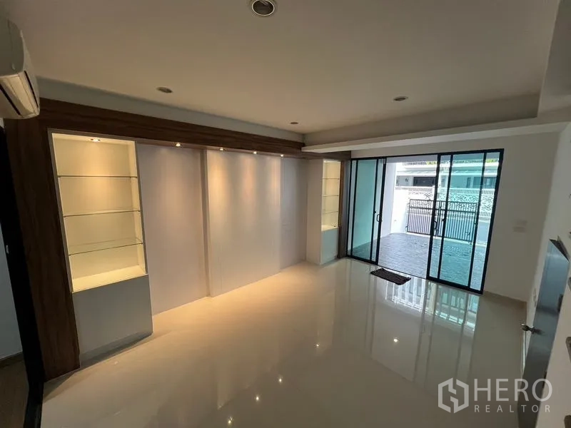 ทาวน์เฮาส์ ให้เช่าหรือขายในKhlong Toei, Bangkok - ห้องนั่งเล่นชั้นล่าง พร้อมชั้นโชว์บิวท์อินและประตูกระจกสไลด์ออกสู่ที่จอดรถ