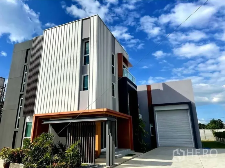 คลังสินค้า ขายในLam Luk Ka, Pathum Thani - ภาพด้านหน้าของโฮมออฟฟิศเชื่อมโกดัง สไตล์โมเดิร์น พร้อมประตูม้วนและสวนหน้าอาคาร