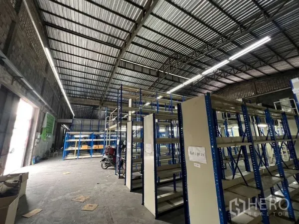 คลังสินค้า ให้เช่าในKhlong Toei, Bangkok - ภายในโกดังโล่ง เพดานเหล็กสูง ไฟสว่าง และชั้นวางสินค้าเหล็กสีน้ำเงิน