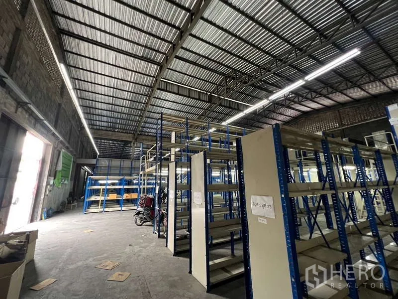 คลังสินค้า ให้เช่าในKhlong Toei, Bangkok - ภายในโกดังโล่ง เพดานเหล็กสูง ไฟสว่าง และชั้นวางสินค้าเหล็กสีน้ำเงิน