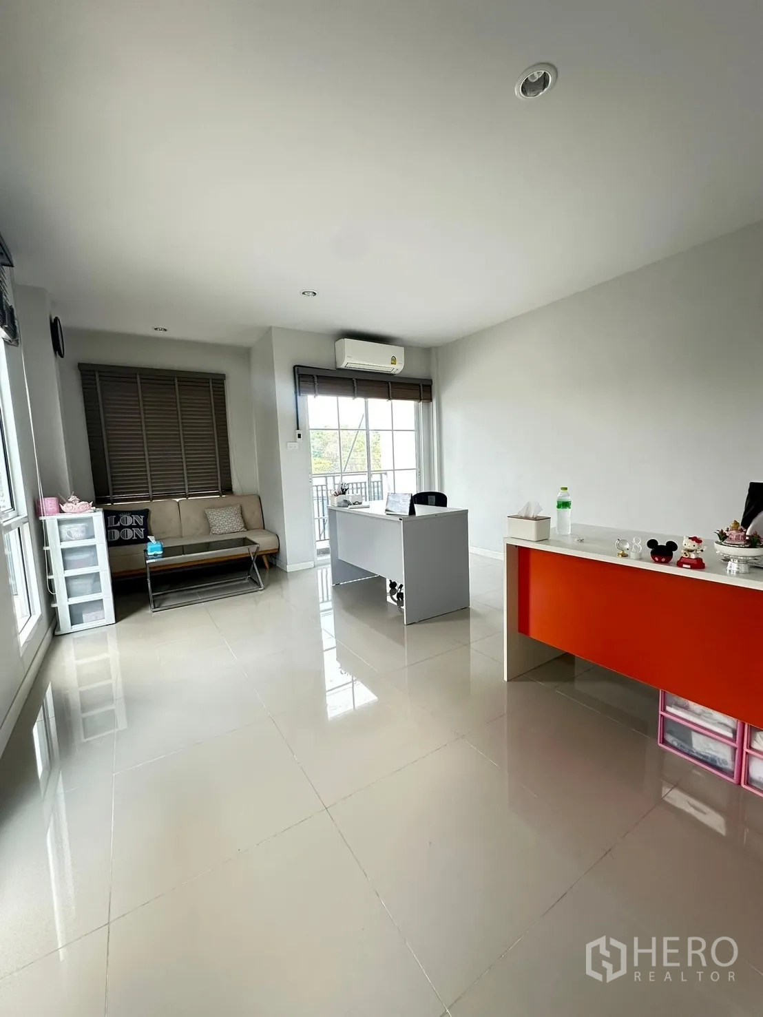 Home Office for rent in Khlong Luang, Pathum Thani - Bright open-plan office with two desks, sofa seating, large windows and a balcony door.
