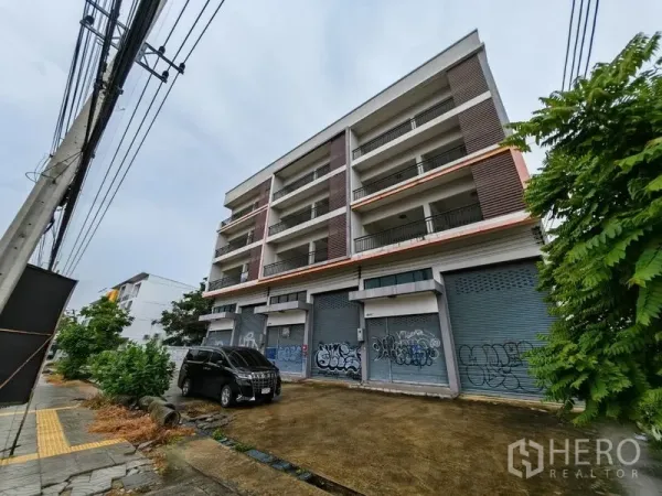 Home Office for rent or sale in Lam Luk Ka, Pathum Thani - Modern multi-storey home office block with ground-floor roller shutters and parking area in Lam Luk Ka.