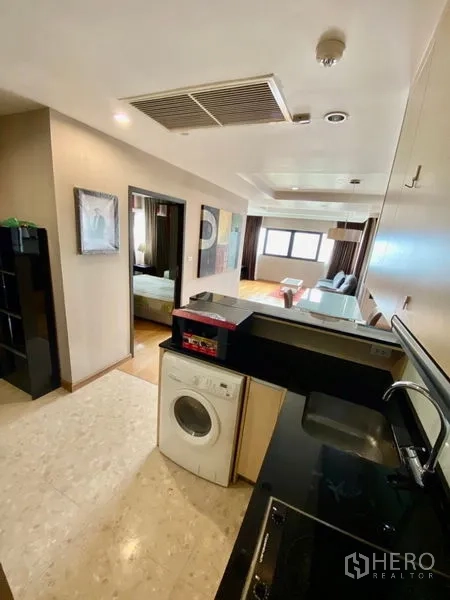 คอนโด ให้เช่าหรือขายในSathon, Bangkok - ครัวขนาดกะทัดรัดมีซิงก์ เตา และเครื่องซักผ้า เชื่อมสู่โซนนั่งเล่น