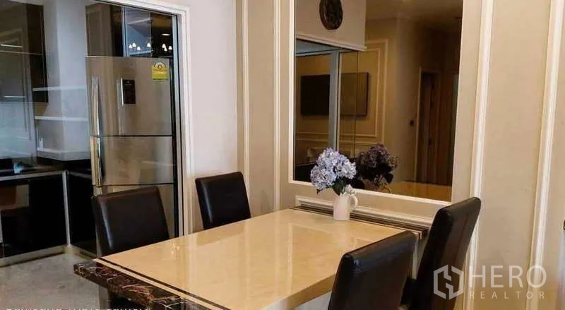 Condominium for rent in Khlong Toei, Bangkok - Dining area with marble table and four leather chairs beside the kitchen.