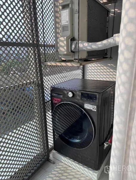 Condominium for rent in Khlong Toei, Bangkok - Utility balcony with front-load washer and air-conditioning unit.