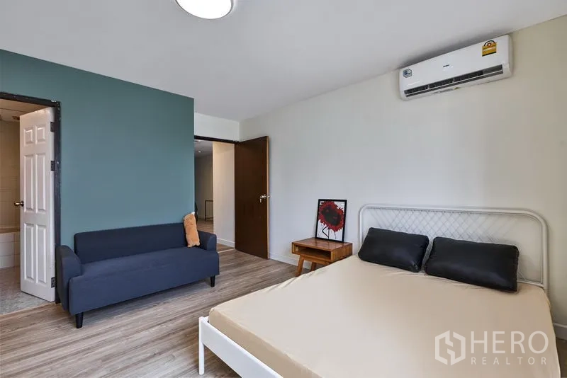 คอนโด ให้เช่าในWatthana, Bangkok - ห้องนอนหลัก ผนังสีเขียว โซฟาและแอร์ พร้อมทางเข้าห้องน้ำ