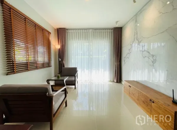 บ้าน ขายในLam Luk Ka, Pathum Thani - มุมนั่งเล่นสว่าง ผนังลายหินอ่อน ม่านโปร่งเต็มบานและบานไม้บังตา