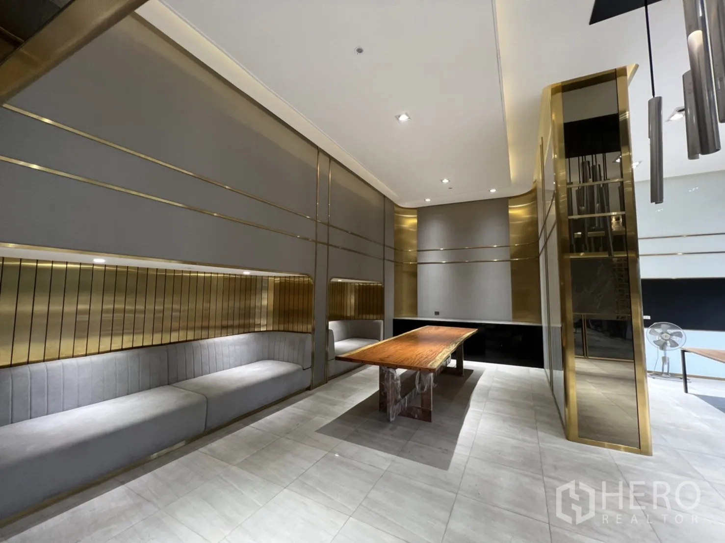 店屋 出租在Phra Khanong, Bangkok - 展示厅休息区，内置沙发、金色装饰与挑高天花。