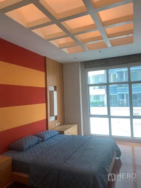 Condominium for rent in Pathum Wan, Bangkok - Second bedroom with striped accent wall, grid‑lit ceiling and large windows.