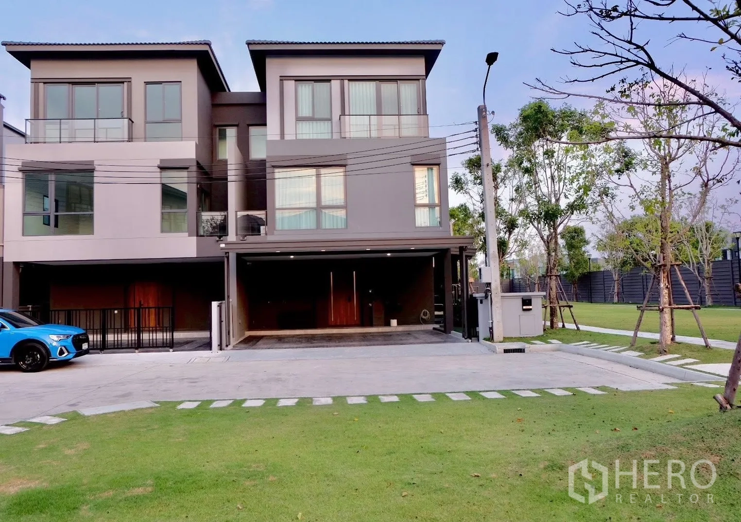 Semi-detached House for sale in Prawet, Bangkok - Modern semi-detached houses with covered carports facing a green lawn.