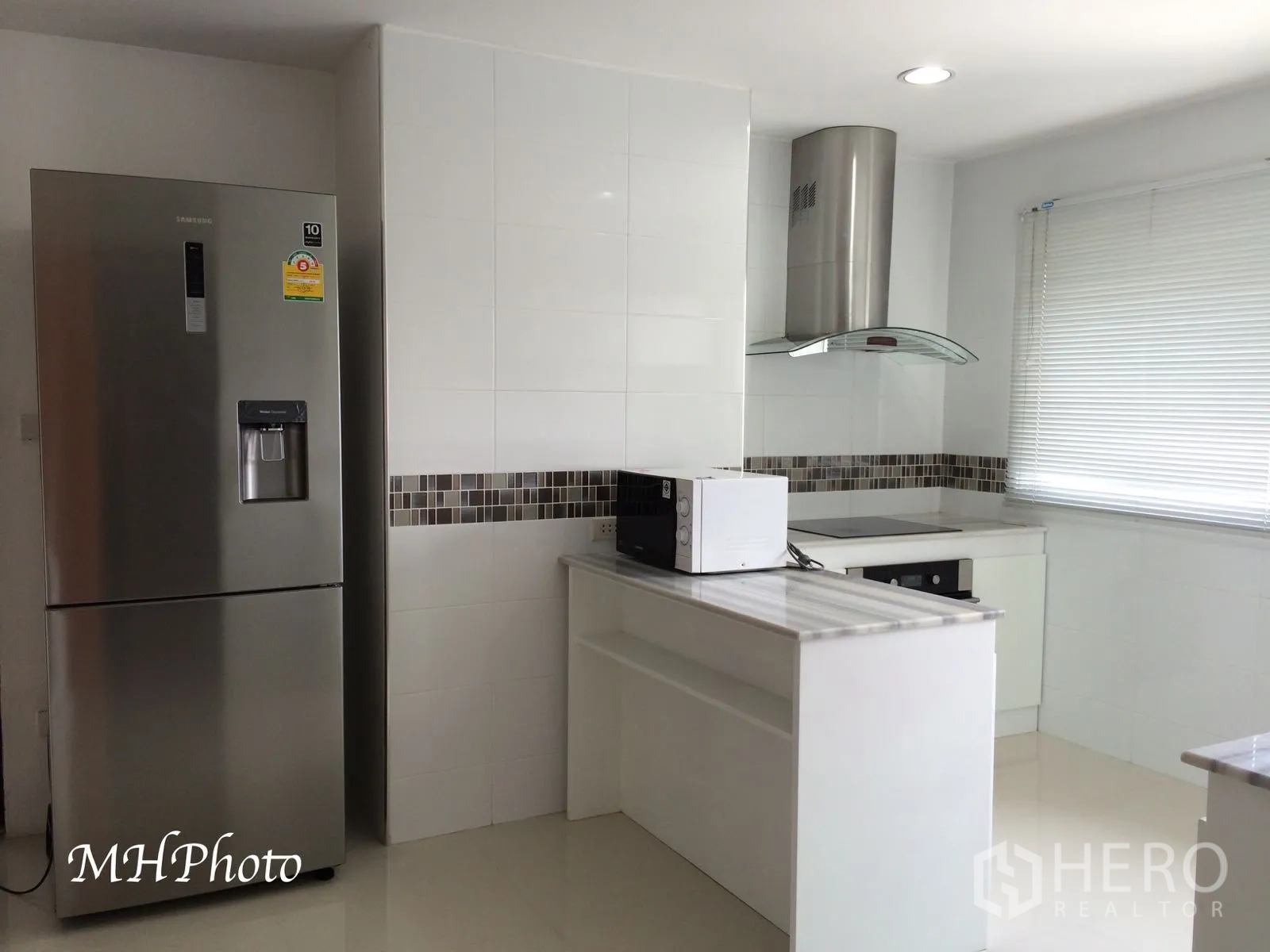 คอนโด ให้เช่าในWatthana, Bangkok - ครัวโทนขาวสว่าง มีไอส์แลนด์ เตาไฟฟ้า เครื่องดูดควัน กระเบื้องโมเสก และตู้เย็นสแตนเลส