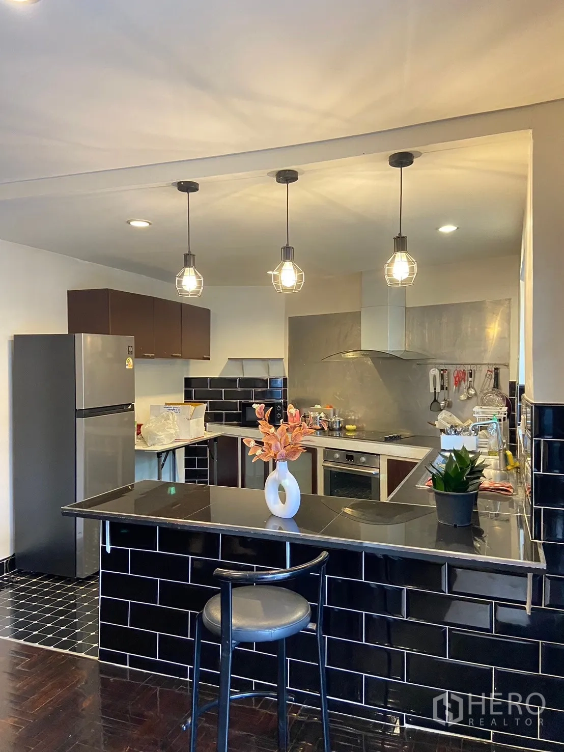 Home Office for rent in Watthana, Bangkok - Modern kitchen with black subway-tile breakfast bar, pendant lights, oven and refrigerator.