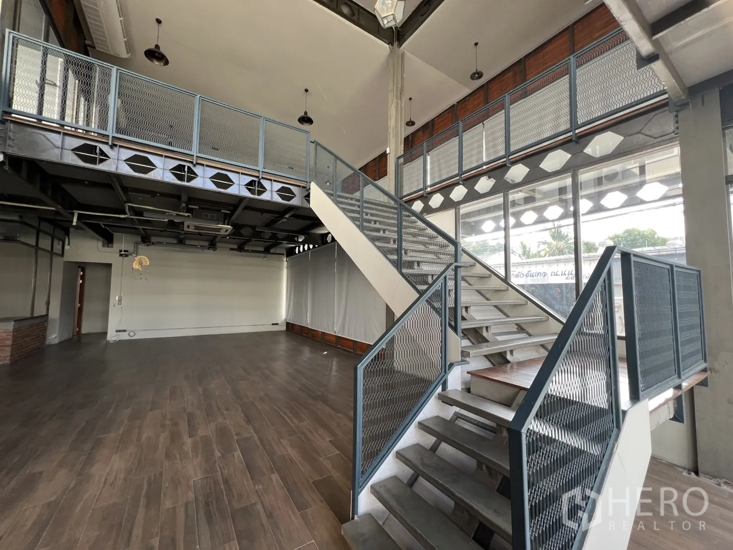 Home Office for rent in Mueang Nonthaburi, Nonthaburi - Feature staircase with metal railings beside floor-to-ceiling windows.