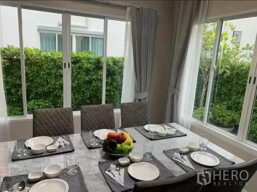 บ้าน ให้เช่า - มุมรับประทานอาหารสว่างด้วยกระจกบานใหญ่ มองเห็นสวนแนวรั้วต้นไม้