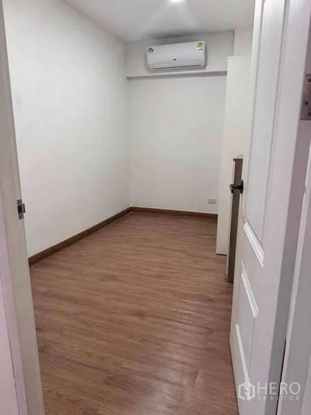 公寓 出租在Sathon, Bangkok - 第二卧或书房，木纹地板、白色墙面与壁挂空调。