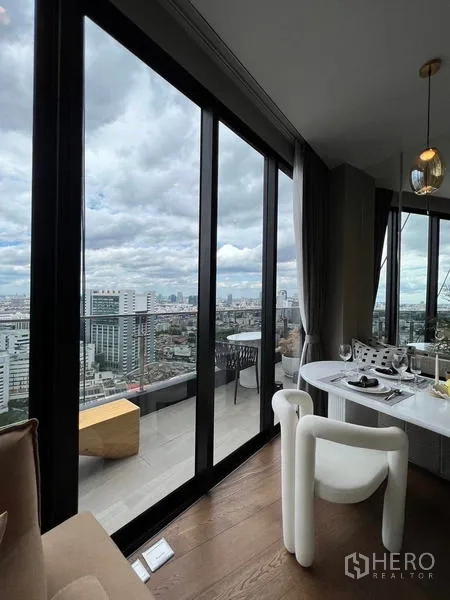 公寓 出租在Ratchathewi, Bangkok - 餐桌靠推拉落地门，连接阳台，眺望天际线。