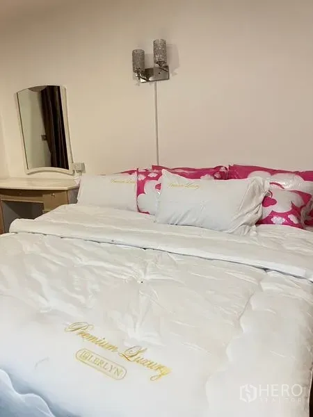 คอนโด ให้เช่าในRatchathewi, Bangkok - ห้องนอนอบอุ่น เตียงใหญ่ชุดผ้าปูสีขาว โคมไฟติดผนัง และโต๊ะเครื่องแป้ง