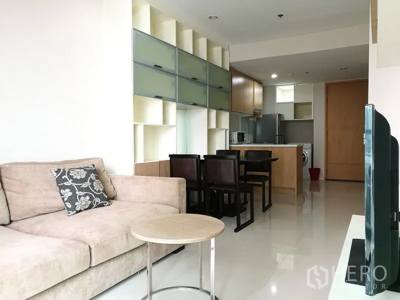 คอนโด ให้เช่าในRatchathewi, Bangkok - พื้นที่นั่งเล่นโอเพ่นแพลน มีโซฟา ชุดโต๊ะทานอาหาร และตู้เก็บของติดผนัง ต่อเนื่องถึงครัวบิวท์อิน