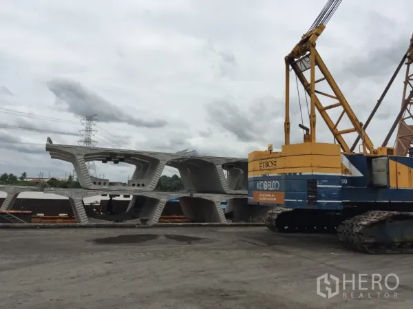 货栈 出租在Pathum Thani - 露天工业场地，履带式起重机与堆放的预制混凝土构件，位于木昂巴吞他尼的仓库。