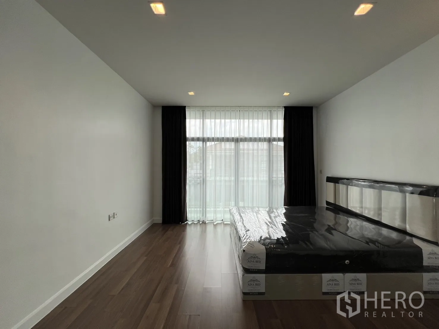 独立式住宅 出租在Bang Kapi, Bangkok - 宽敞主卧，通高窗帘与柔和灯光。