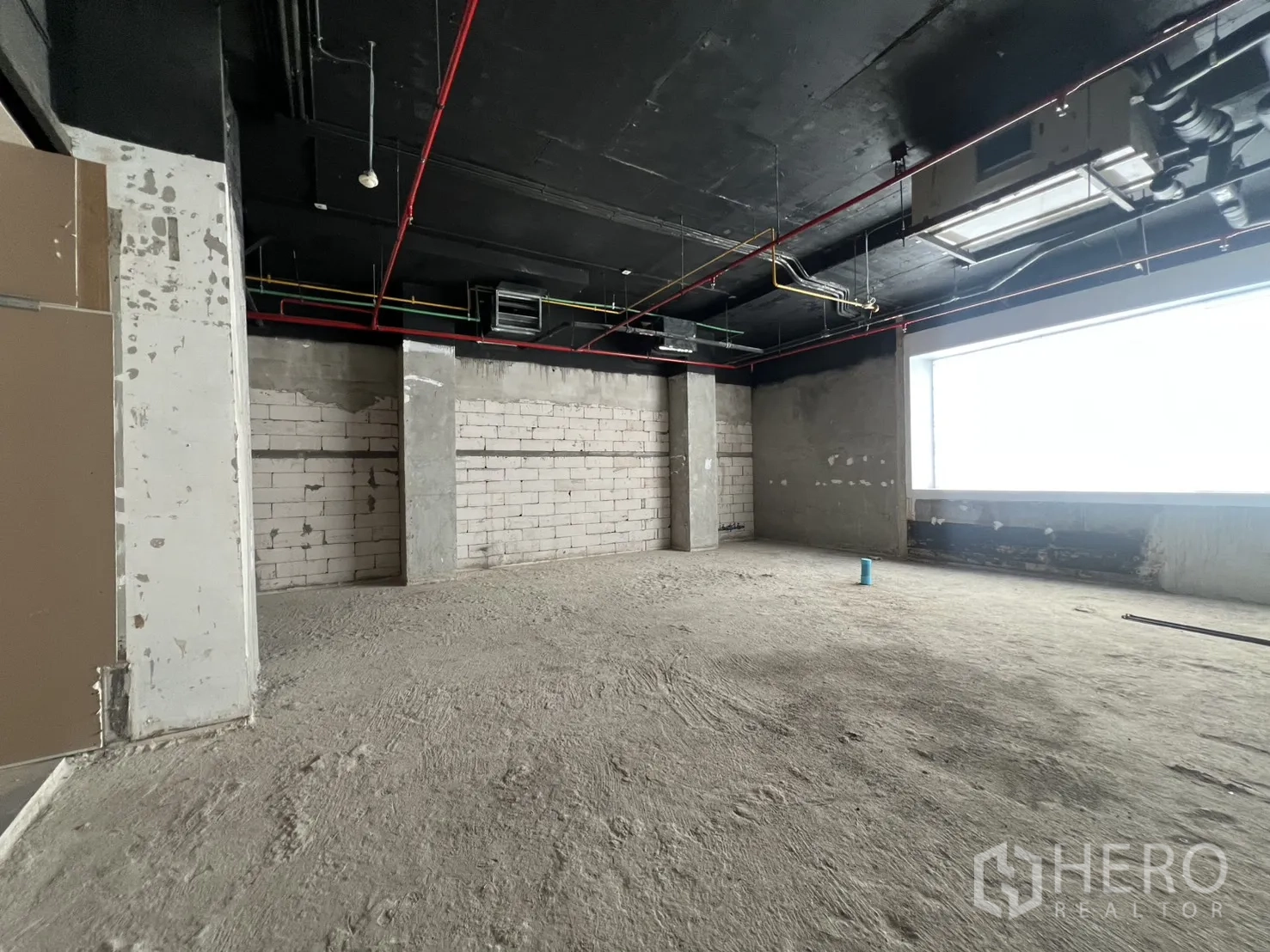 Retail Space for rent in Pathum Wan, Bangkok - Raw retail unit with exposed black ceiling, ducts, and a large window.