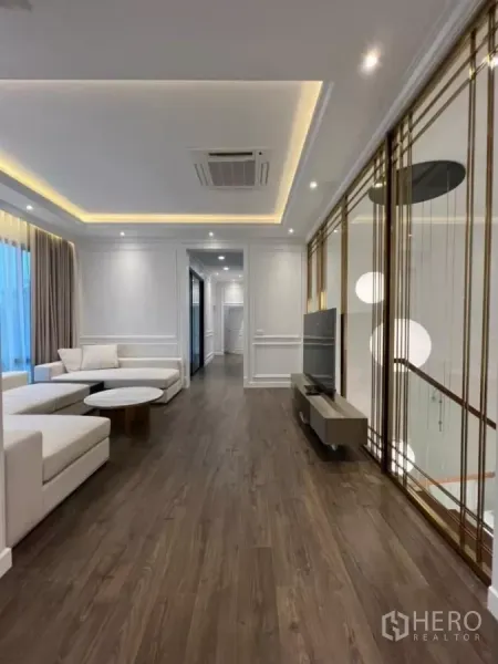 独立式住宅 出租在Phaya Thai, Bangkok - 客厅木地板与灯槽天花，电视区及楼梯隔屏。