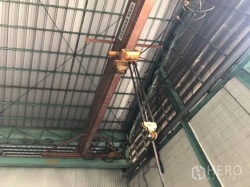 Warehouse for rent in Samut Prakan - Ceiling-mounted chain hoist and beam inside the warehouse.