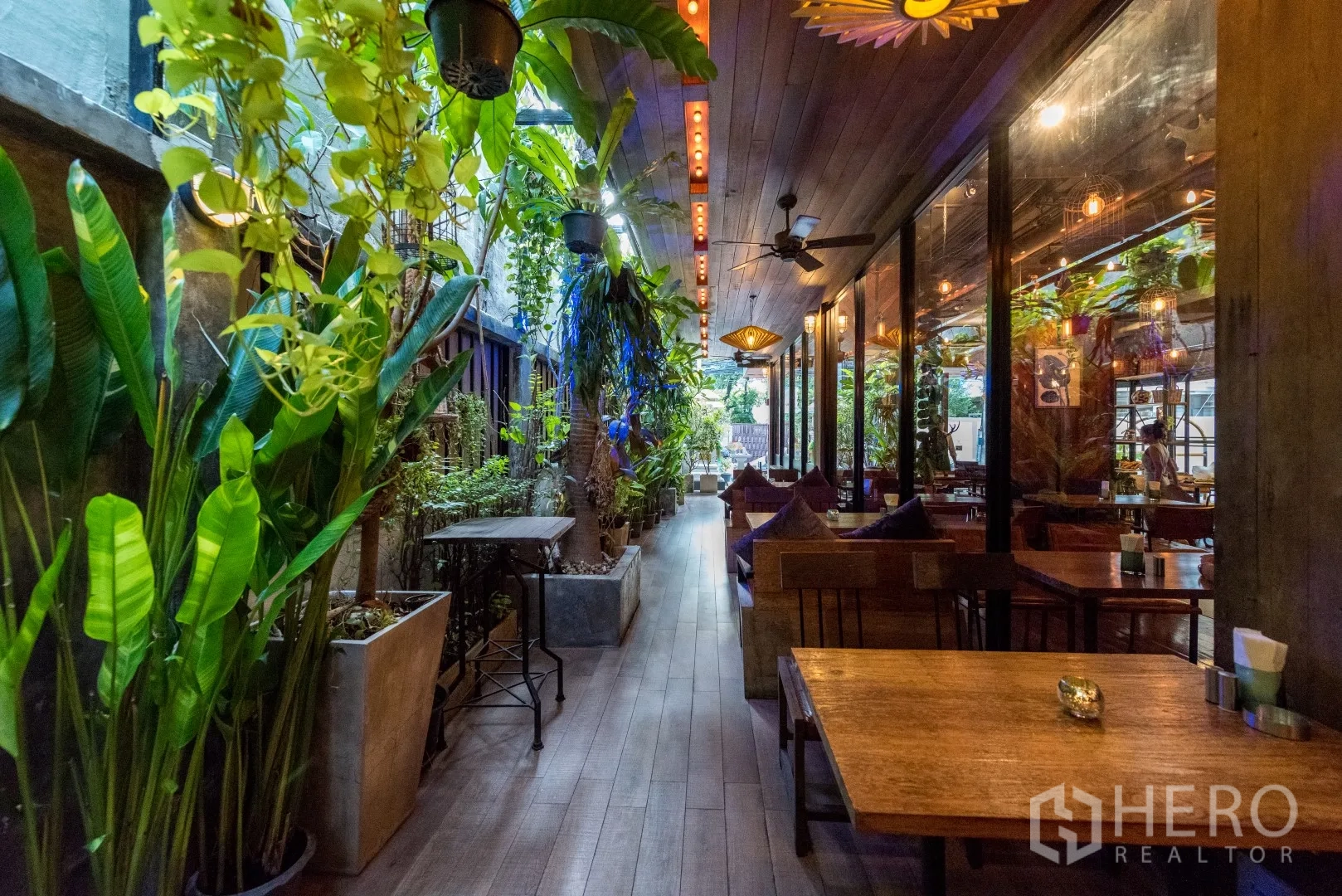 พื้นที่ขายปลีก ให้เช่าในWatthana, Bangkok - โถงทางเดินกลางแจ้ง มีสวนกระถาง ผนังกระจกติดห้องอาหาร และไฟห้อยโทนอบอุ่น