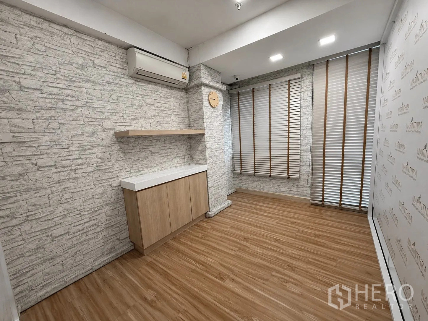 Home Office for rent or sale in Yan Nawa, Bangkok - Bright office room with stone-textured walls, shelf, cabinet, and window blinds.
