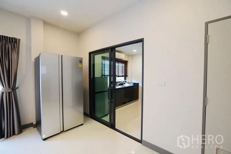 Detached House for rent in Bang Phli, Samut Prakan - View of double-door fridge beside sliding glass doors to the kitchen.
