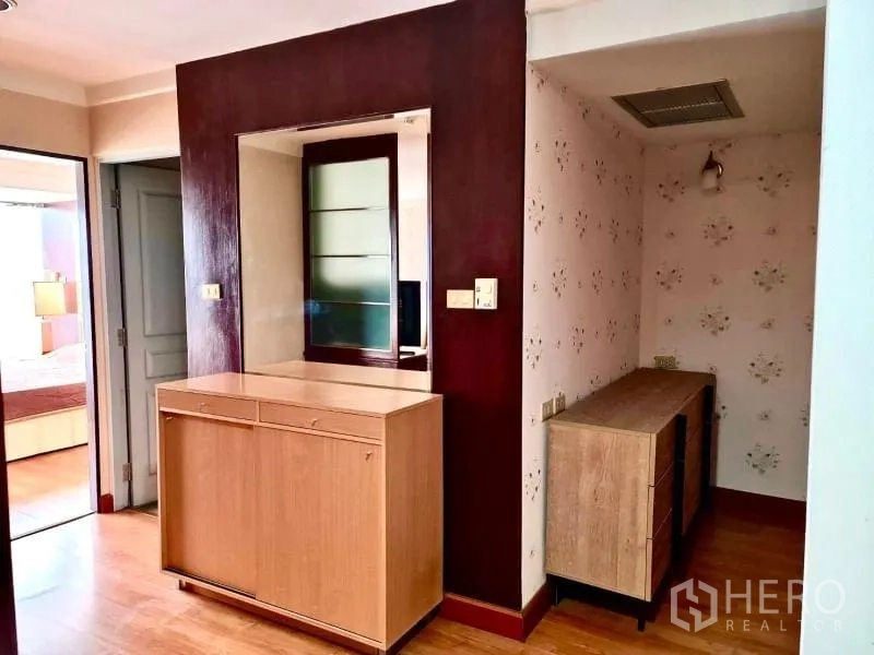 公寓 出租在Khlong Toei, Bangkok - 入口走廊设木柜与墙面镜，花卉墙纸点缀。