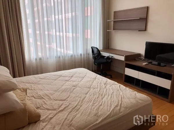 公寓 出租或出售在Khlong Toei, Bangkok - 次卧带书桌、壁架和电视，大窗配窗帘采光充足