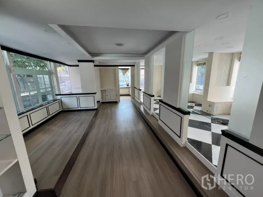 Retail Space for rent - Wood‑floored showroom with wraparound windows and built‑in cabinets.