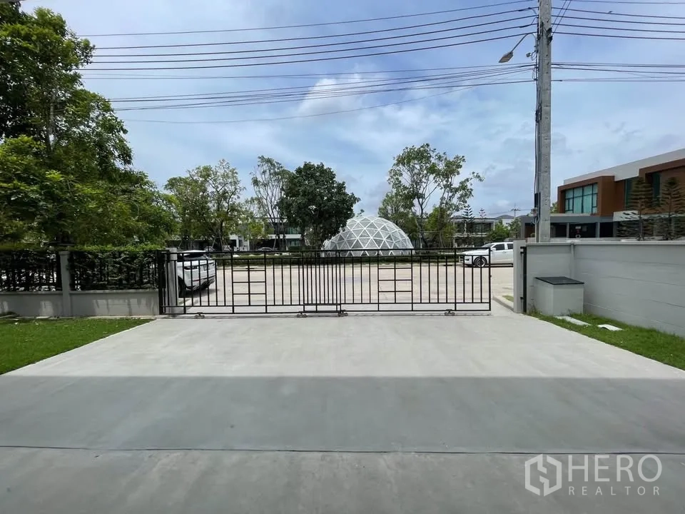 บ้านเดี่ยว for rent or sale in Bang Phli, Samut Prakan - ทางเข้าบ้านพร้อมลานจอดรถและประตูรั้วเลื่อนติดถนนภายในโครงการ