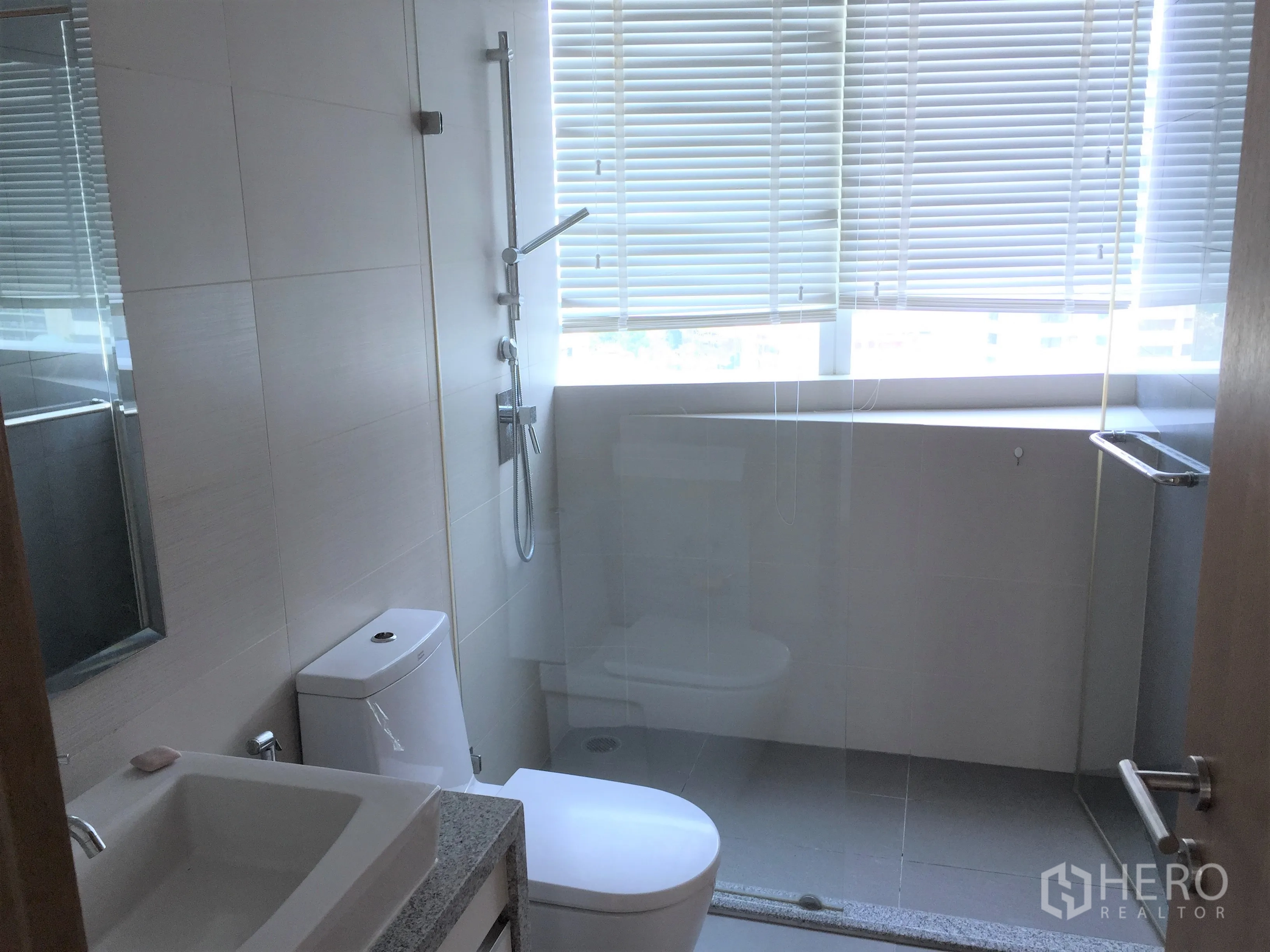 คอนโด ให้เช่าหรือขายในKhlong Toei, Bangkok - ห้องน้ำพร้อมตู้กระจกอาบน้ำ อ่างล้างหน้า และหน้าต่างบานใหญ่พร้อมมู่ลี่