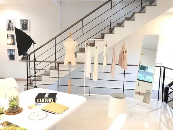 Shophouse for rent in Lat Phrao, Bangkok - Open-plan studio level with staircase, garment rack and full-length mirror, ideal for showroom or office use.