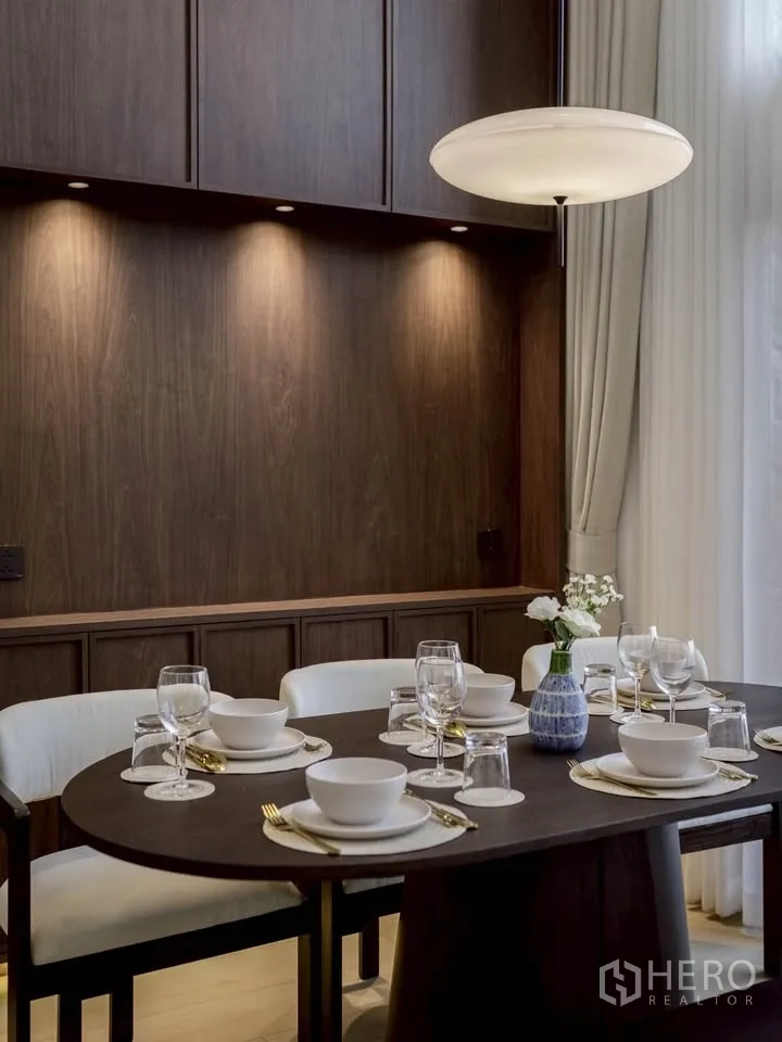 Condominium for rent in Khlong Toei, Bangkok - Close-up of elegant dining table setting under a round pendant light.